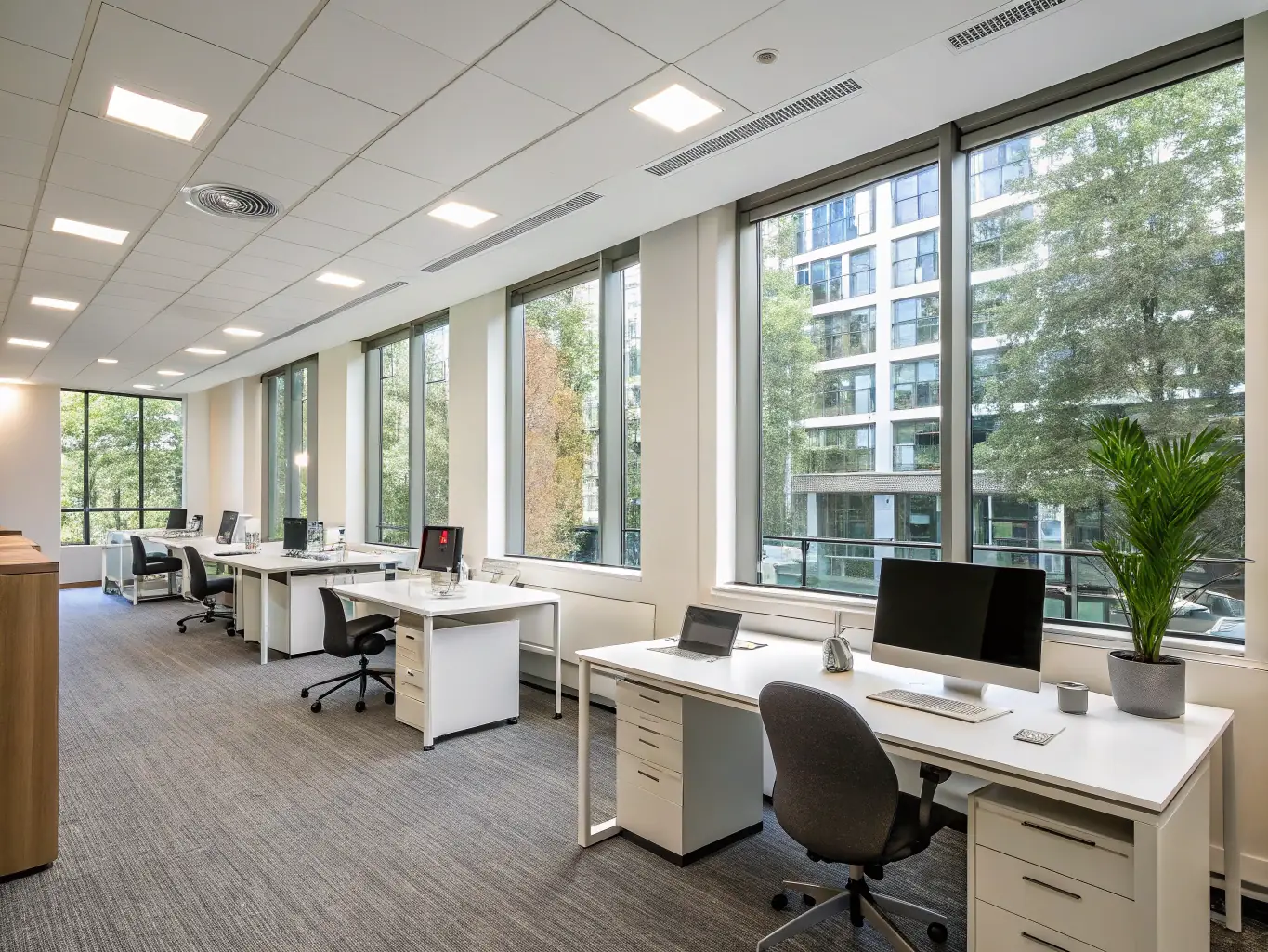 A brightly lit, modern office space with employees working comfortably, showcasing a clean and organized environment achieved through professional cleaning services.